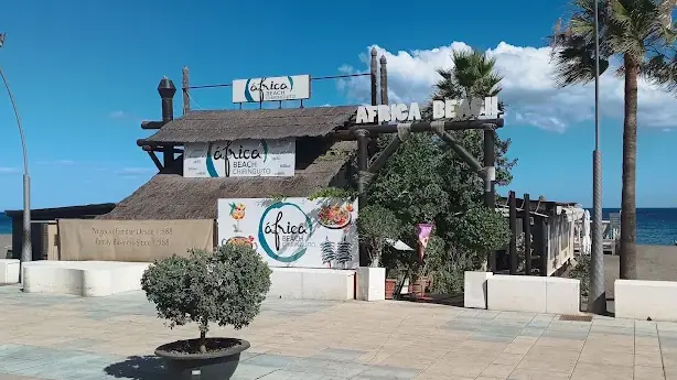 Entrada del Chiringuito África Beach desde el paseo marítimo de Estepona, con el rótulo «Africa Beach»